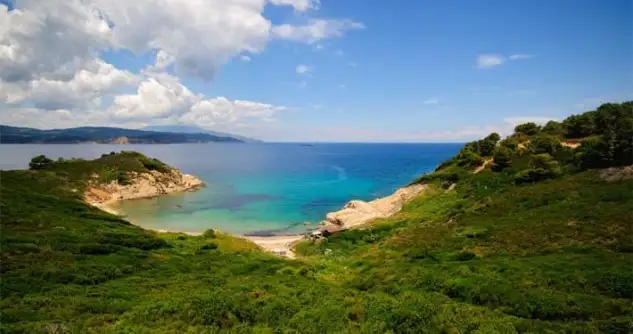 la Isla de Skiathos Destaca del resto de las islas, junto a Skópelos, por la naturaleza especialmente hermosa y rebosante de vegetación. Esta situada frente al Monte Pilion y el norte de la gran isla de Eubea. Es muy recomendable, desde esta isla, dada su proximidad, hacer una extensión a la bella Skópelos e incluso la visita de un día a la romántica y solitaria isla de Alónisos. Tiene 44 km de costa de increíbles playas y un destacado paisaje natural, caracterizado por la abundantes extensiones de pino mediterráneo que penetran hasta el mar. Aunque se trata de una isla pequeña, es muy conocida en Europa, por lo que turísticamente es muy visitada. Combinada con su vecina Skópelos puede ser una maravillosa mezcla para unas estupendas vacaciones. En esta isla nació una de los más queridos y famosos poetas helenos, Alexandros Papadiamantis. El coche no se hace tan necesario como en otras islas. Existen autocares regulares y continúas barcas que desde numerosos lugares transportan a los bañistas a lo largo de su costa. De las excursiones en barca no olviden visitar la preciosísima playa de Lalaria y las famosas cuevas azules (Galazia Spilia).