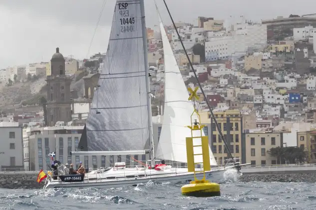 El Proteina 65 (CN Sada) de Manuel Batallán cruzando la línea de llegada con Las Palmas de Gran Canaria de fondo. Foto: Q. Curbelo