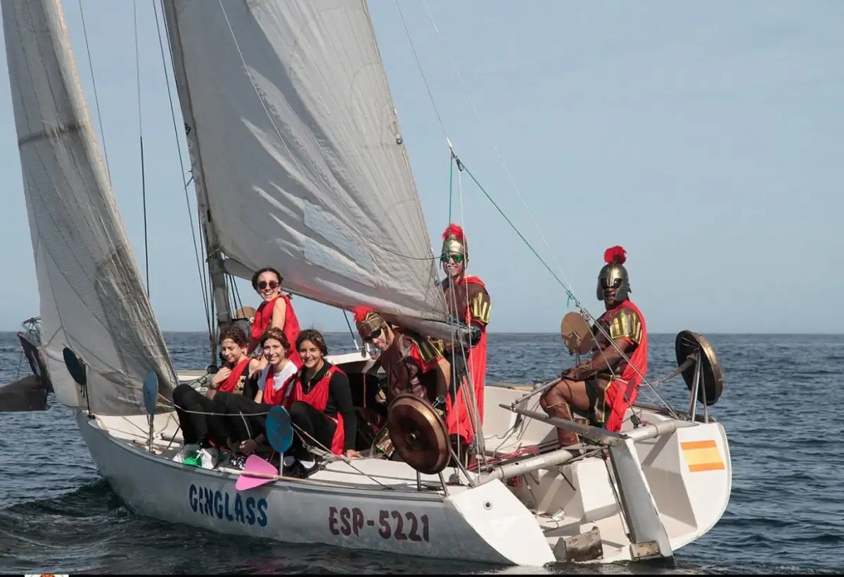 Llama la atención las reglas especiales y de uso obligatorio para la prueba, como por ejemplo: que las tripulaciones y el barco se disfrazarán después de la finalización de la primera vuelta completa al recorrido, ya en la línea de llegada deberán estar completamente disfrazados y situarse de pie en la banda más cercana al barco del comité para que los jueces puedan fotografiar y certificar el cumplimiento de las reglas (Foto Félix G.Muñiz)