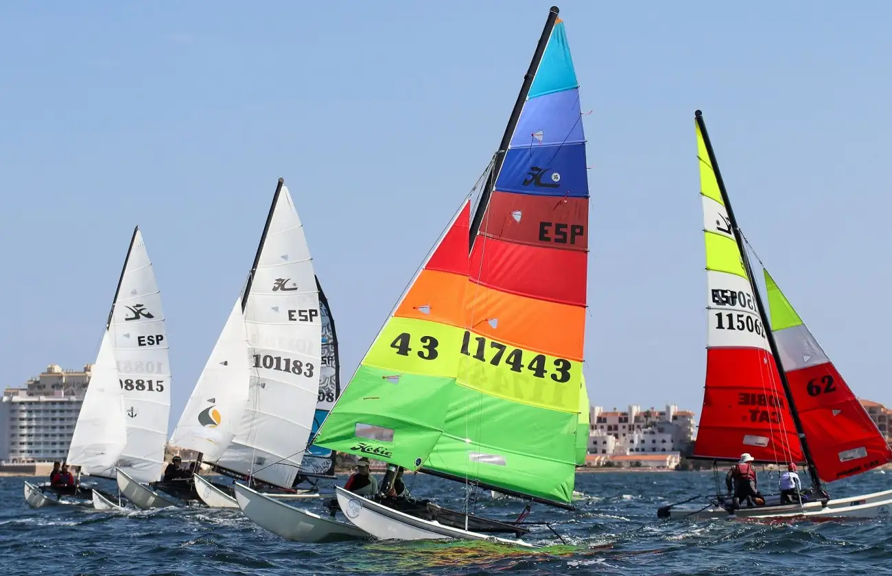 Jornada espectacular bajo unas magníficas condiciones de viento para este tipo de embarcación, pudiéndose completar tres pruebas y cumpliendo el guión con José Mª Fanlo y Carmen Fanlo en Hobie Cat 16, Mitch y Ruben Booth en F18 y Manuel Calavia en Clase A liderando la general provisional de sus respectivas clases (Foto Pep Portas)
